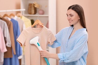 Woman steaming shirt on hanger at home