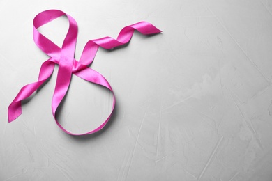 Photo of 8 March greeting card design with pink ribbon and space for text on light grey background, top view. International Women's day