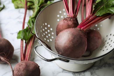 Photo of Raw ripe beets on white marble table