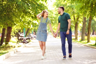 Happy young couple in green park on sunny spring day