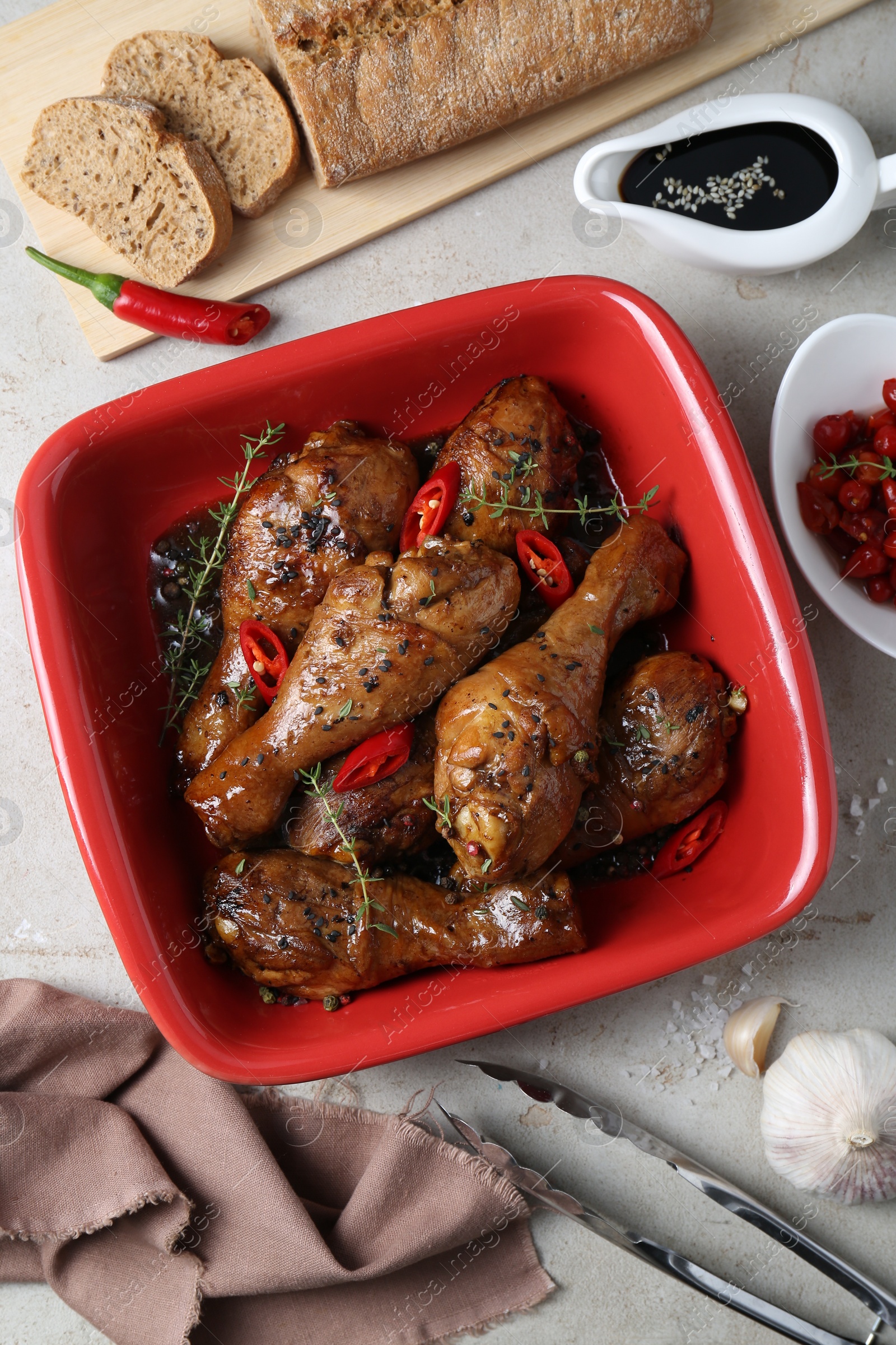 Photo of Flat lay composition of chicken legs glazed with soy sauce and ingredients on light table