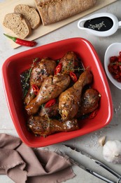 Flat lay composition of chicken legs glazed with soy sauce and ingredients on light table