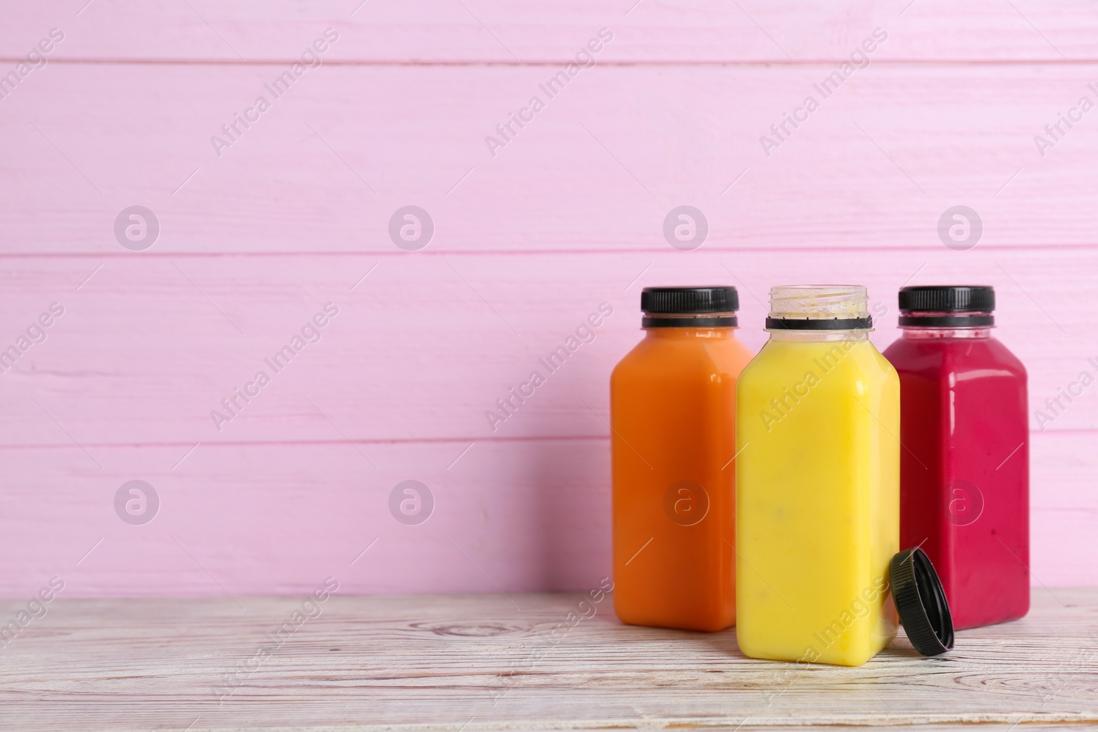 Photo of Bottles with delicious detox smoothies on table