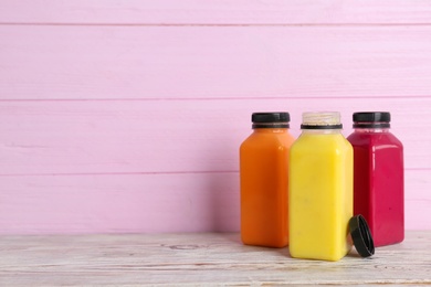 Photo of Bottles with delicious detox smoothies on table