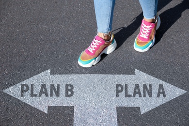 Image of Choosing between Plan A and Plan B. Woman near pointers on road, closeup view
