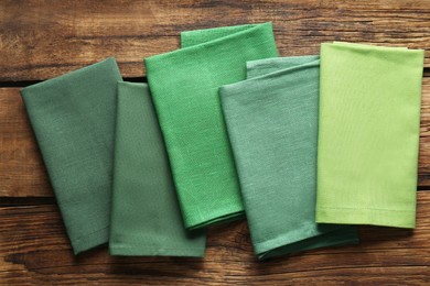 Photo of Different kitchen napkins on wooden table, flat lay
