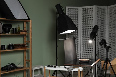 Photo of Professional equipment and salad with prosciutto on table in photo studio. Food photography