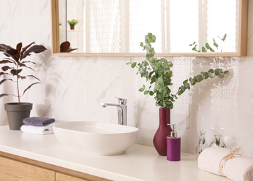 Stylish bathroom interior with countertop, mirror and plants. Design idea