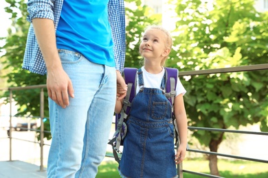 Young father taking his little child to school outdoors