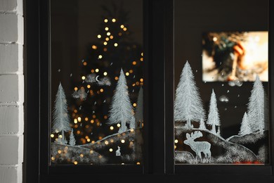 Beautiful drawing made with artificial snow on window. Christmas decor