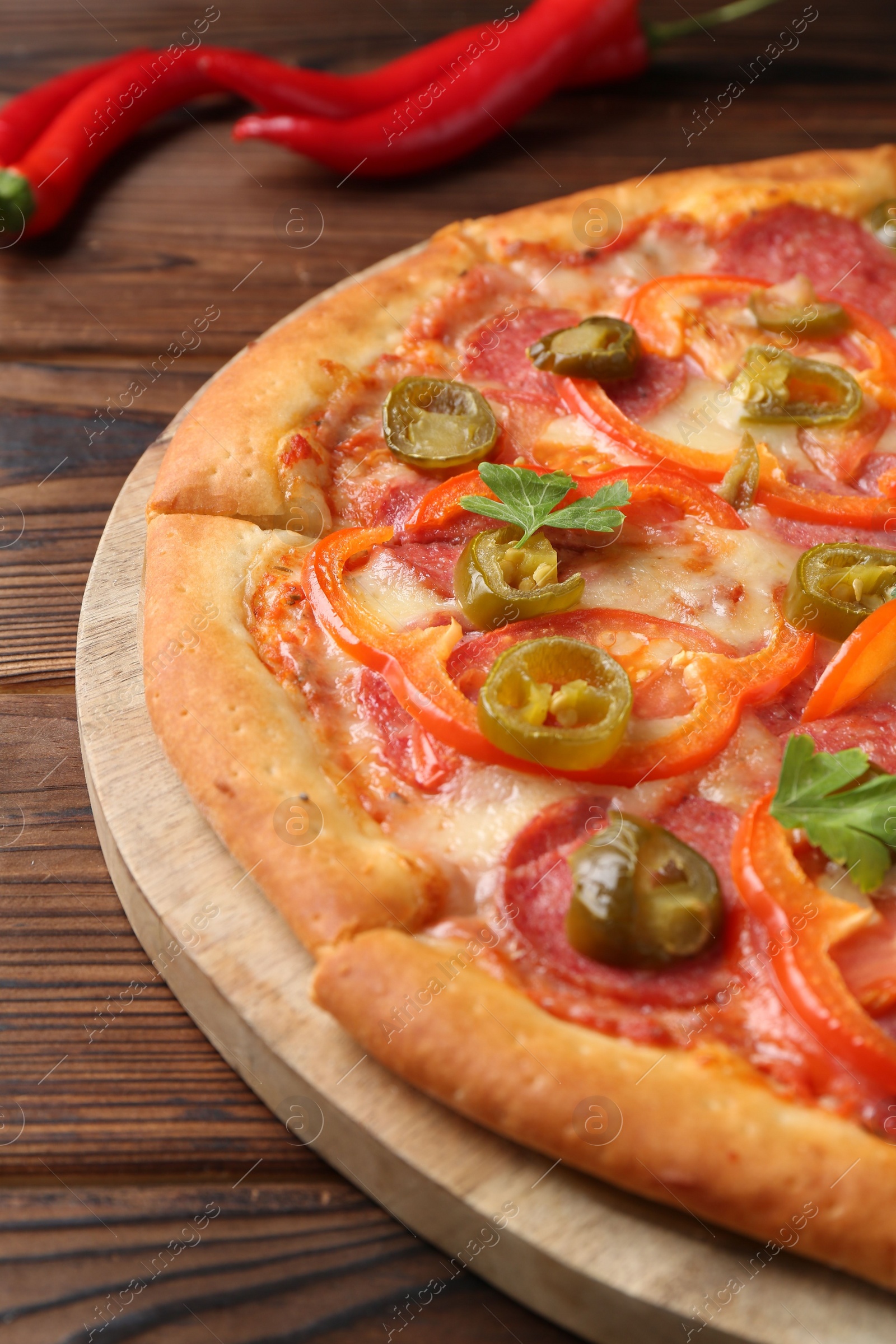 Photo of Delicious pizza Diablo on wooden table, closeup