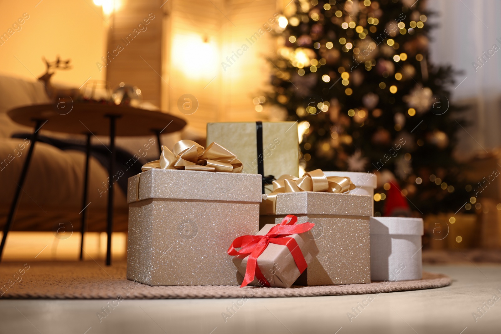 Photo of Beautiful gift boxes in room decorated for Christmas. Bokeh effect