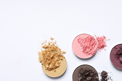 Photo of Different crushed eye shadows on white background, flat lay. Space for text