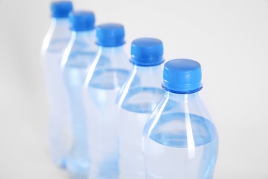 Photo of Plastic bottles with pure water on white background, closeup