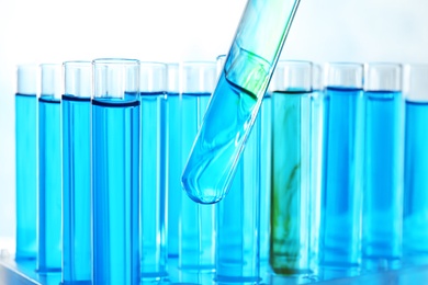 Photo of Taking test tube with liquid sample, closeup