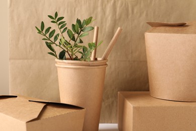 Photo of Eco friendly food packagings and green twigs on table, closeup