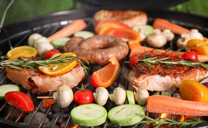 Photo of Barbecue grill with delicious cooked meat and vegetables, closeup