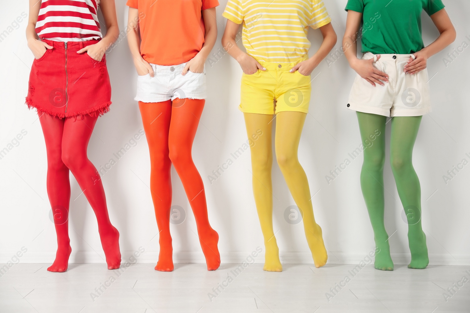 Photo of Women wearing bright tights near white wall, closeup