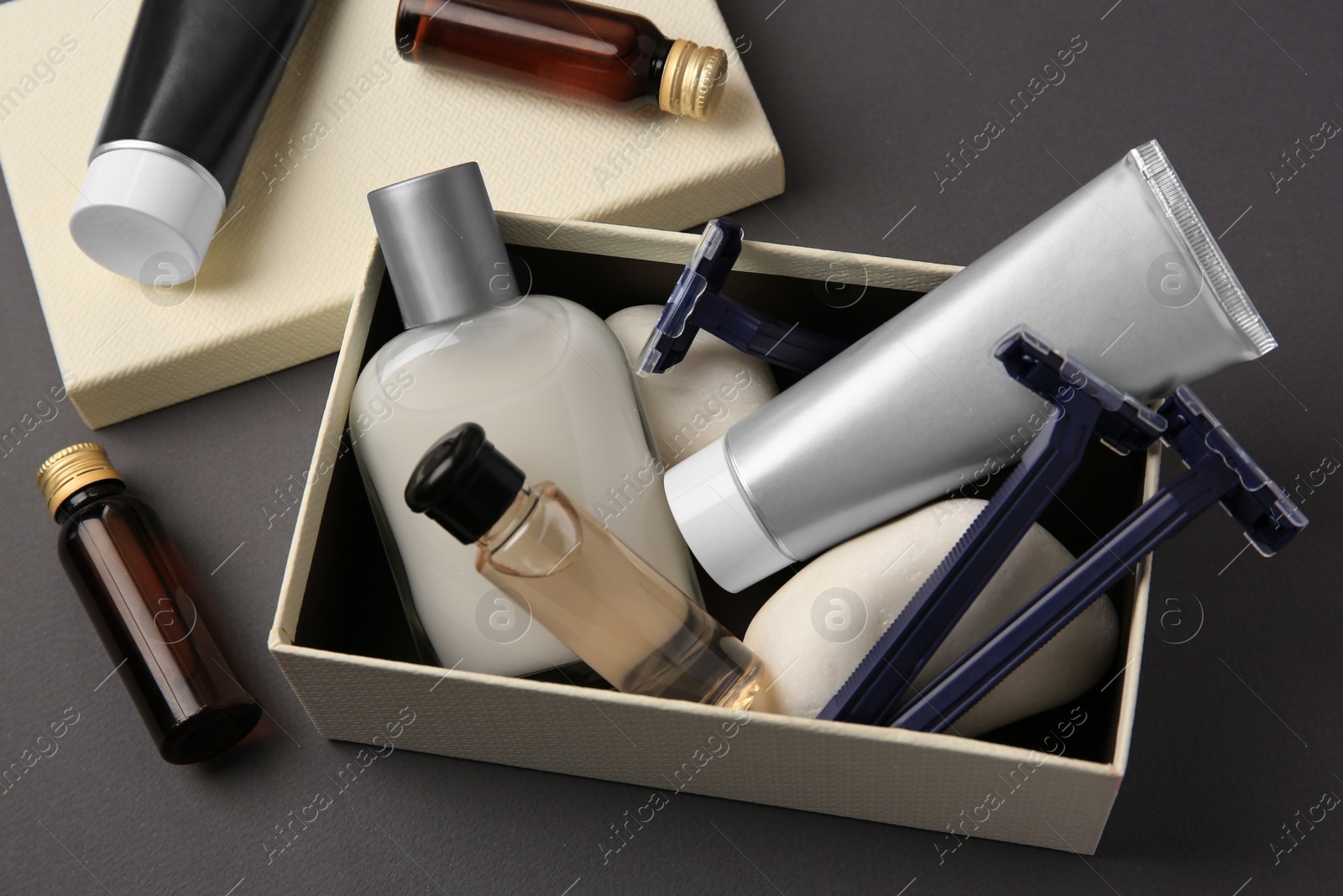 Photo of Different men's shaving accessories and box on dark grey background