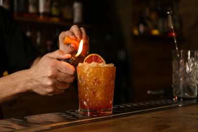 Bartender preparing fresh alcoholic cocktail at bar counter, closeup