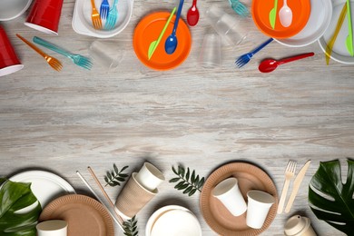 Photo of Flat lay composition with plastic and eco disposable tableware on white wooden background. Space for text