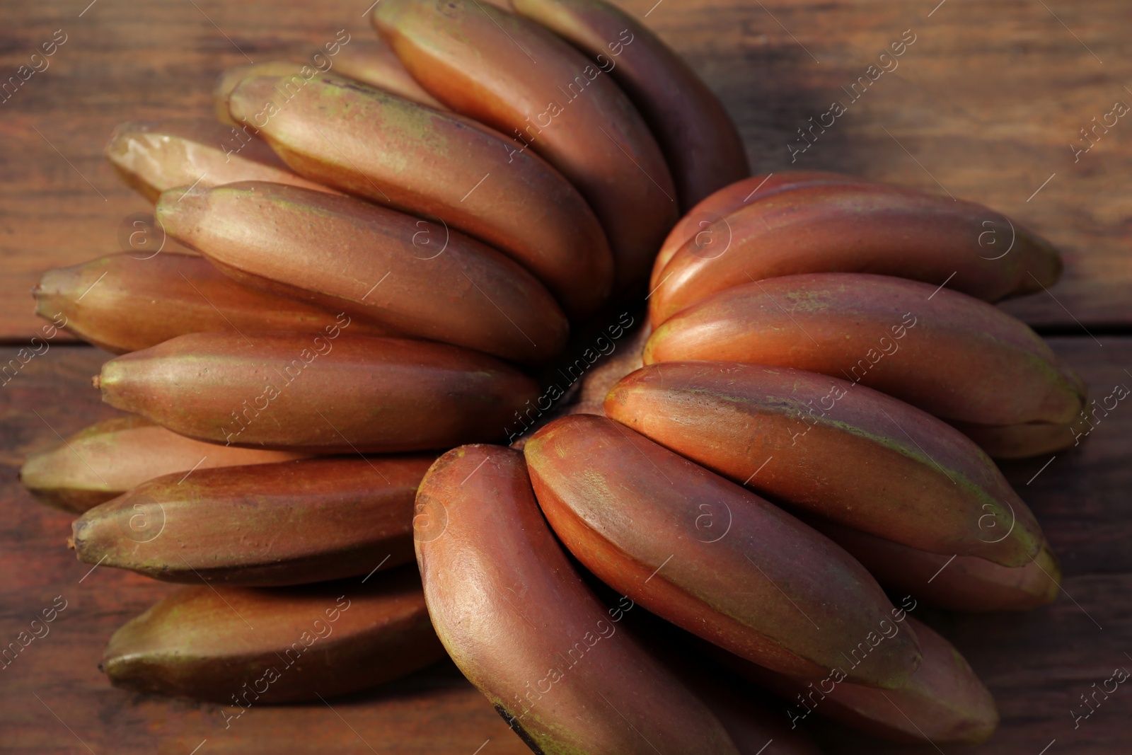 Photo of Tasty purple bananas on wooden table, closeup