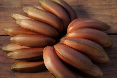 Tasty purple bananas on wooden table, closeup