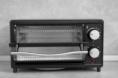 One electric oven on light grey table, closeup. Cooking appliance