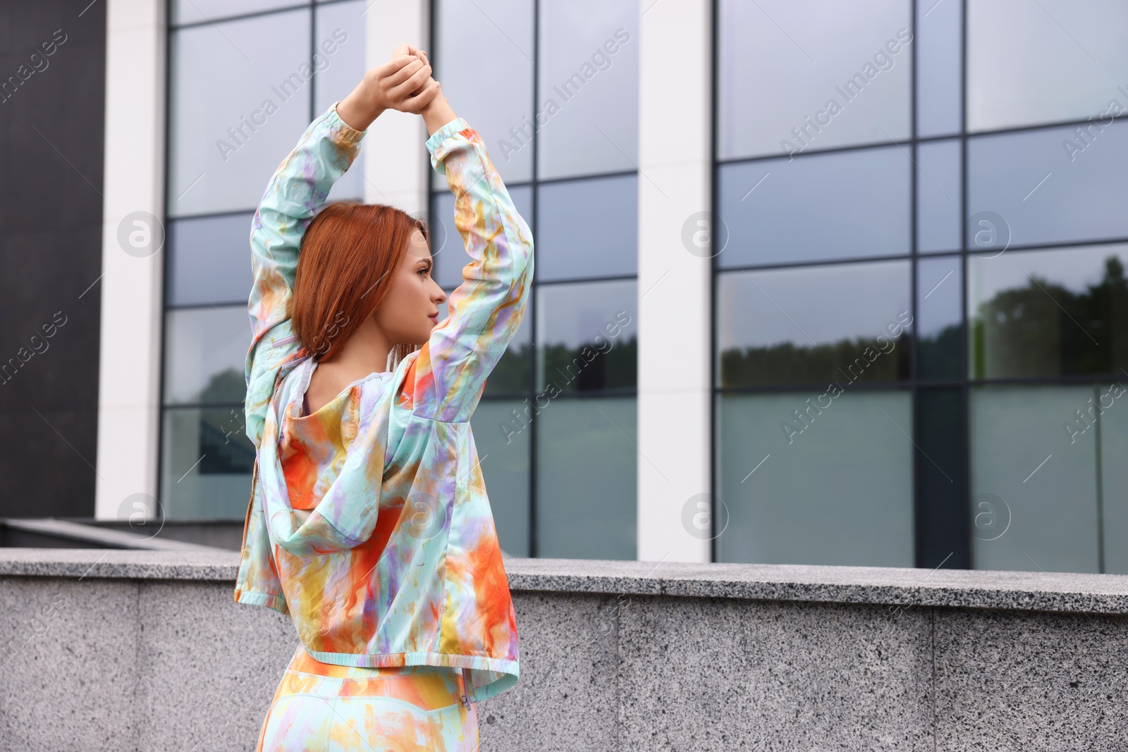 Photo of Beautiful woman in gym clothes doing exercises on street, space for text