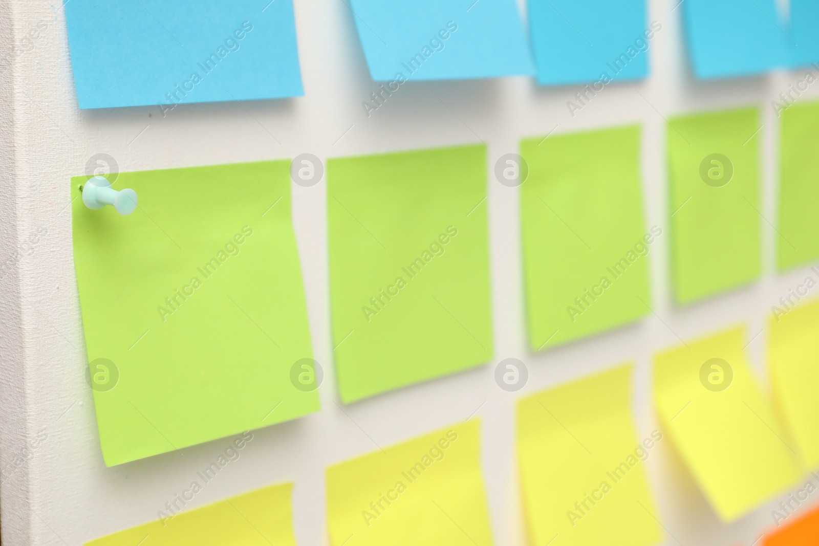 Photo of Blank colorful paper notes on white board, closeup