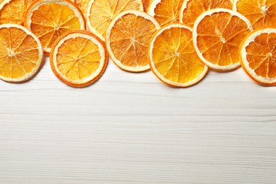 Dry orange slices on white wooden table, flat lay. Space for text