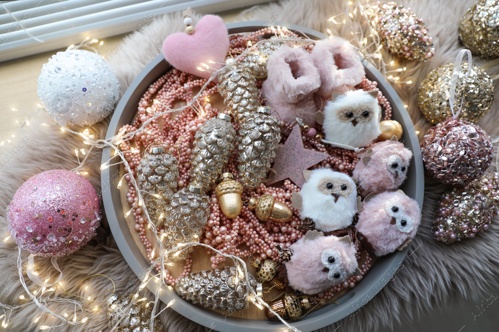 Photo of Beautiful Christmas tree baubles, toys and fairy lights on window sill, above view