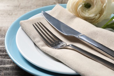 Photo of Stylish table setting with cutlery and flower on wooden background, closeup