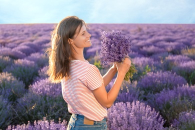 Photo of Young woman with bouquet in lavender field