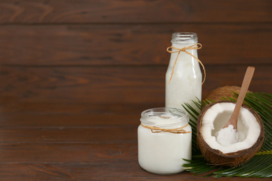 Photo of Composition with organic coconut oil on wooden table, space for text. Healthy cooking