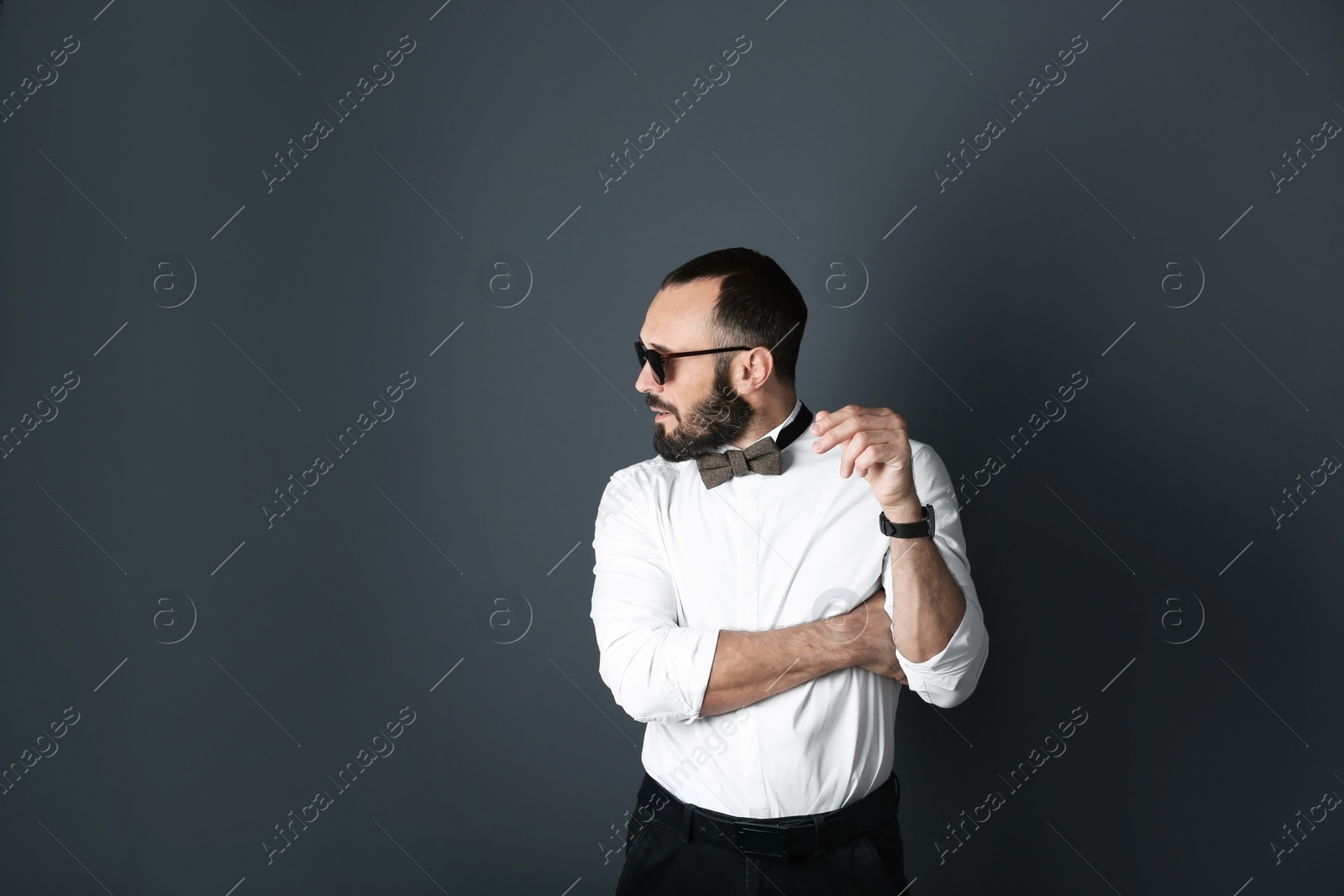 Photo of Portrait of handsome tattooed man on grey background