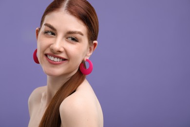 Photo of Portrait of smiling woman on purple background. Space for text