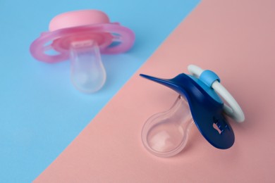 Photo of Different baby pacifiers on bright color background