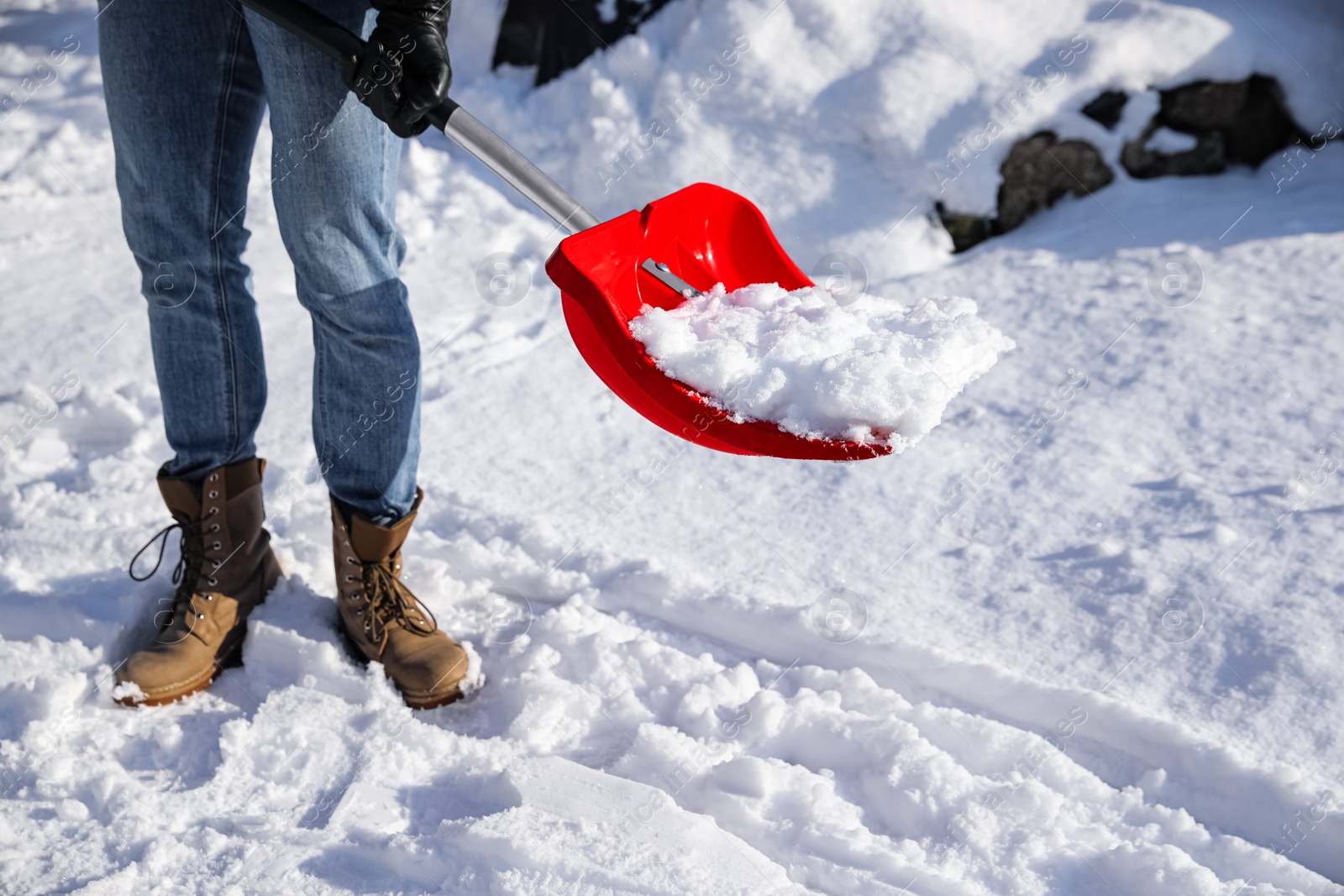 Photo of Person shoveling snow outdoors on winter day, closeup