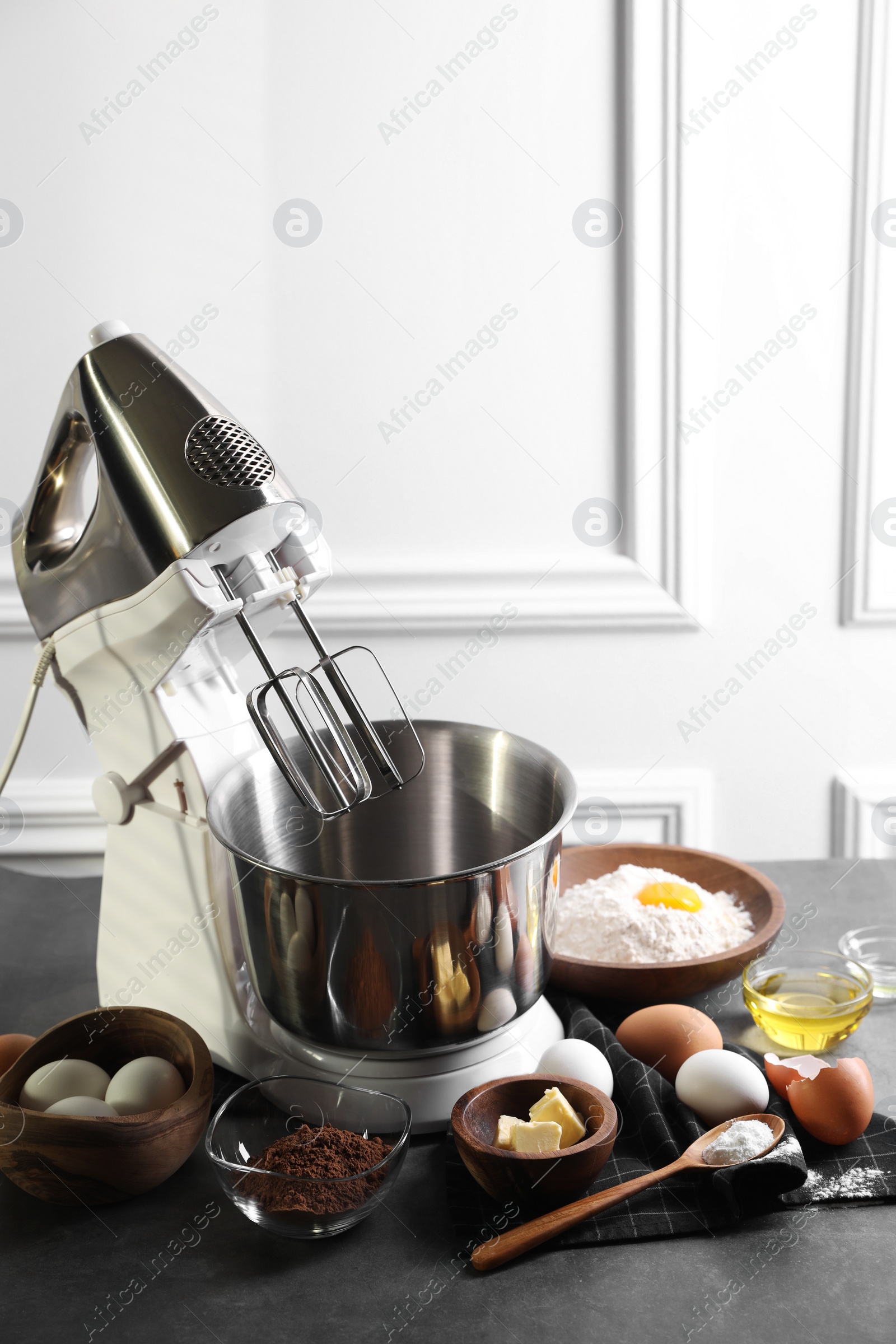 Photo of Stand mixer and different ingredients for dough on grey table