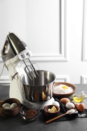 Stand mixer and different ingredients for dough on grey table