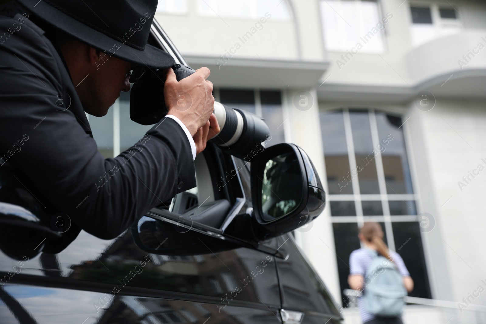 Photo of Private detective with camera spying from car