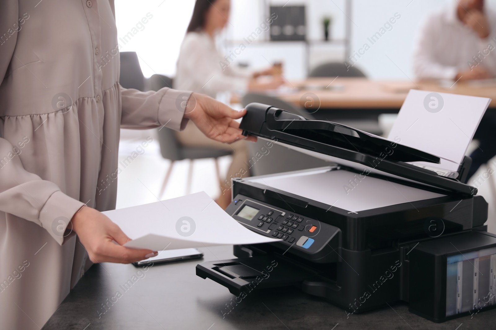 Photo of Employee using modern printer in office, closeup