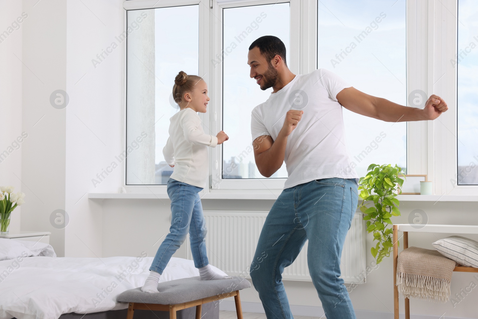 Photo of Little girl with her father spending time together at home. International family