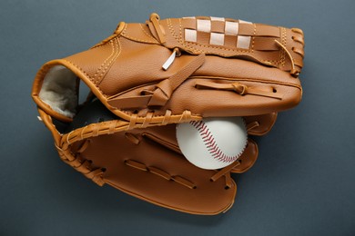 Photo of Catcher's mitt and baseball ball on dark background, top view. Sports game