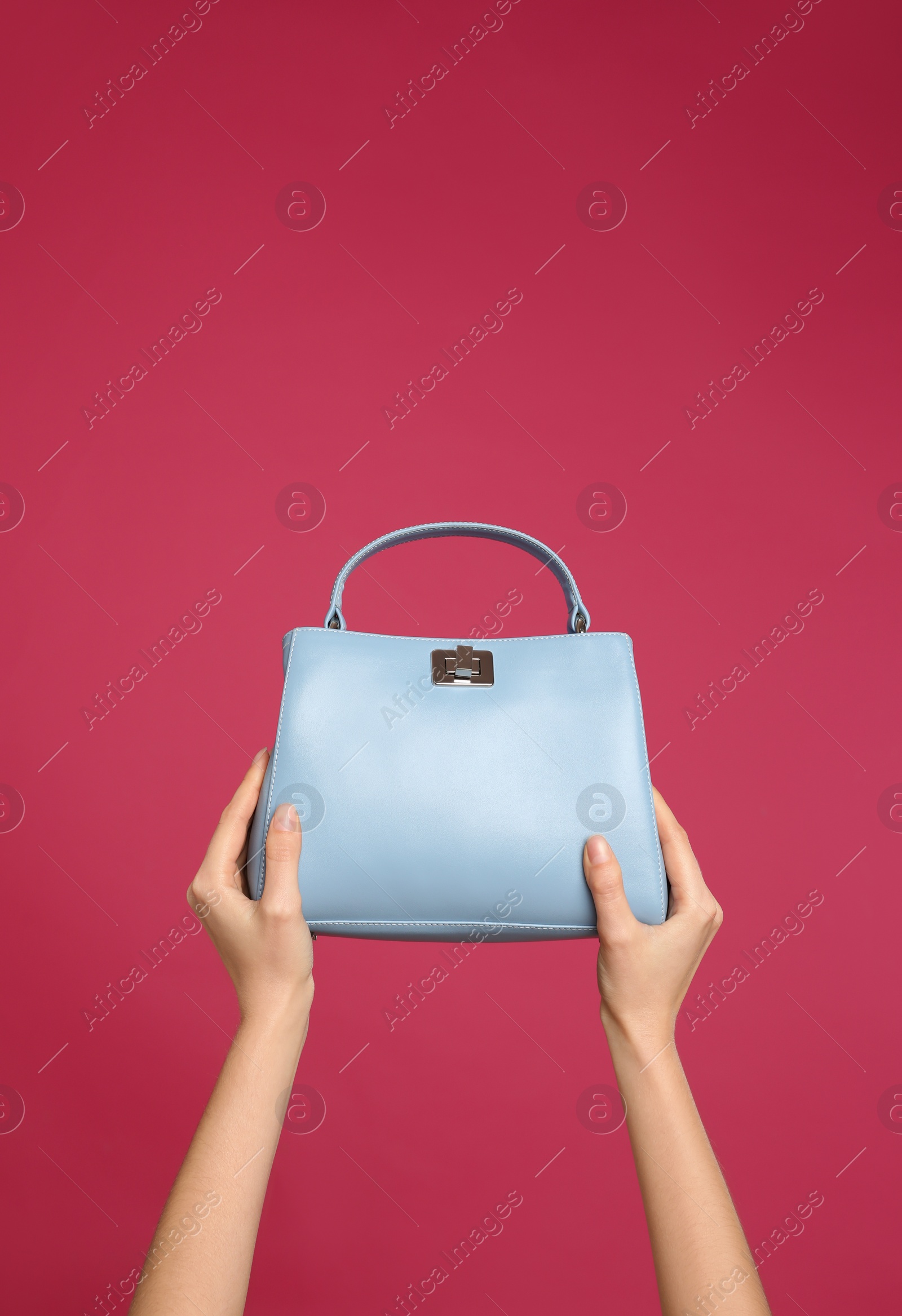 Photo of Woman holding stylish handbag on pink background, closeup