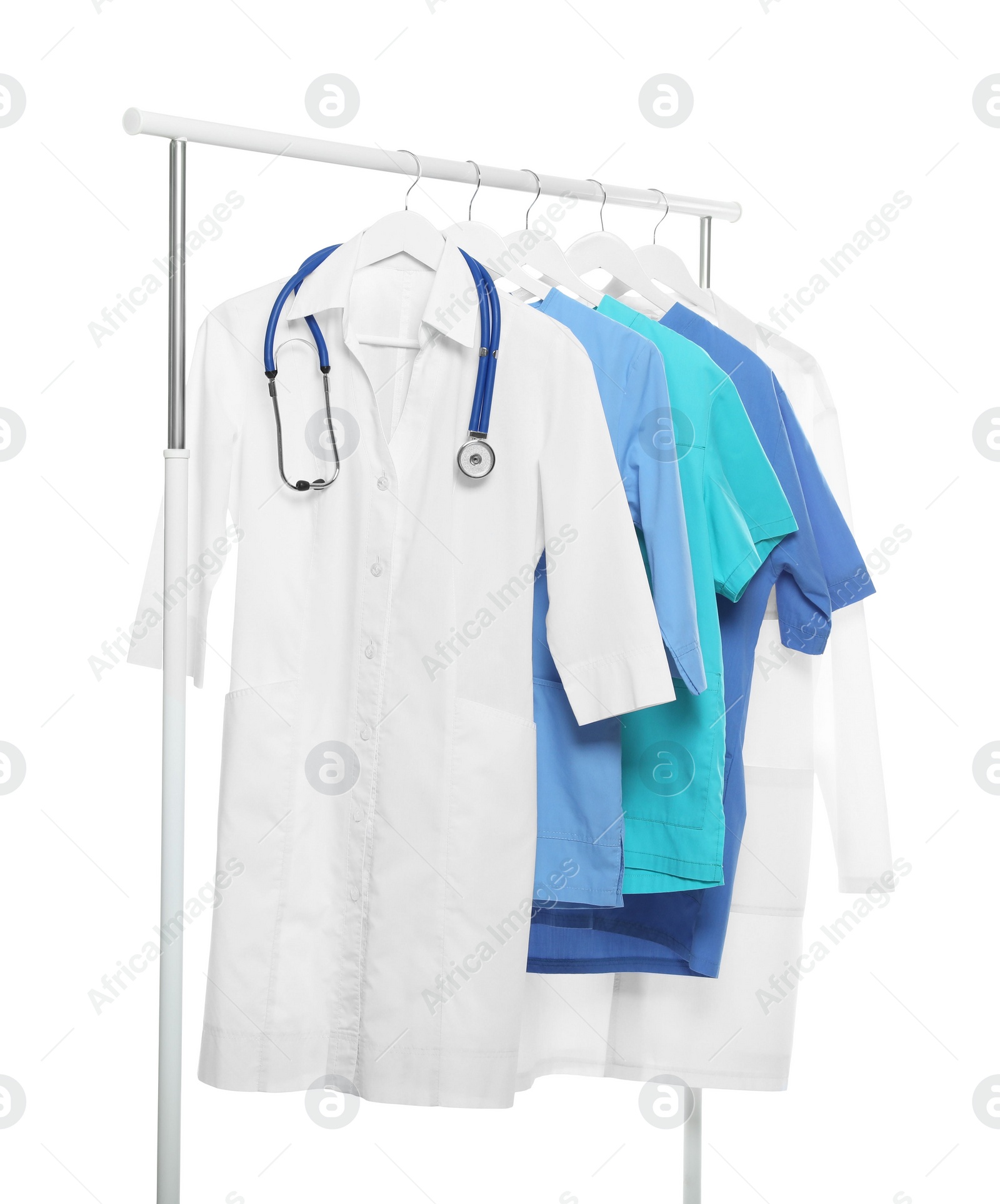 Photo of Doctor's gown with stethoscope and different medical uniforms on rack against white background