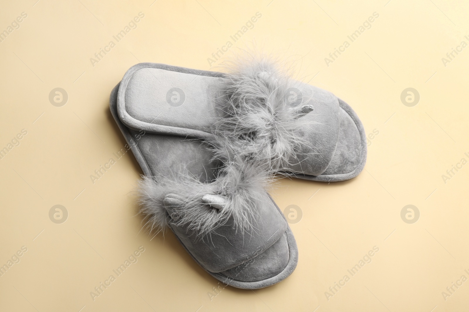 Photo of Pair of stylish soft slippers on beige background, flat lay