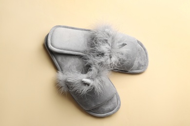 Pair of stylish soft slippers on beige background, flat lay