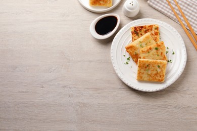 Photo of Delicious turnip cake with parsley served on wooden table, flat lay. Space for text